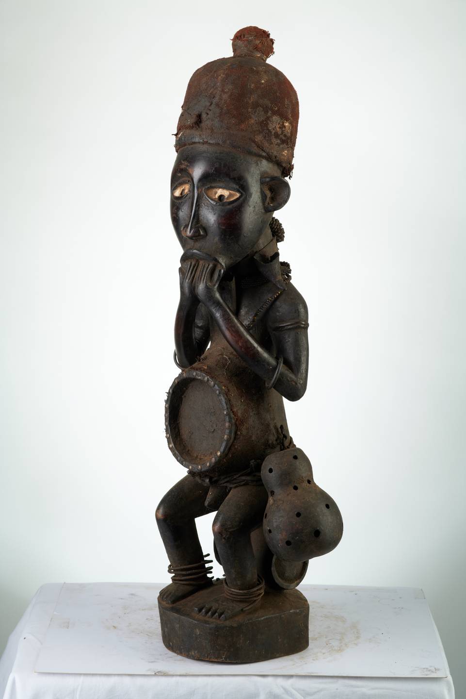 Kongo n°1982, d`afrique : R.D.C., statuette Kongo n°1982, masque ancien africain Kongo n°1982, art du R.D.C. - Art Africain, collection privées Belgique. Statue africaine de la tribu des Kongo n°1982, provenant du R.D.C., 1982 :Fétiche Sundy ou Ndindu dans le  N.O.du Kongo ( N.W.).Il est assis sur un tanneau,porte un bonnet inclus les nkissis,ainsi que les nkissis portés sur le ventre ,le dos et la nuque. Des anneaux métaliques autour des bras et des jambes.Une ceinture tressée autour de la taille avec une calabasse.Des yeux blancs avec des pupilles noirs incrustées.Les deux mains portés à la bouche. . art,culture,masque,statue,statuette,pot,ivoire,exposition,expo,masque original,masques,statues,statuettes,pots,expositions,expo,masques originaux,collectionneur d`art,art africain,culture africaine,masque africain,statue africaine,statuette africaine,pot africain,ivoire africain,exposition africain,expo africain,masque origina africainl,masques africains,statues africaines,statuettes africaines,pots africains,expositions africaines,expo africaines,masques originaux  africains,collectionneur d`art africain
