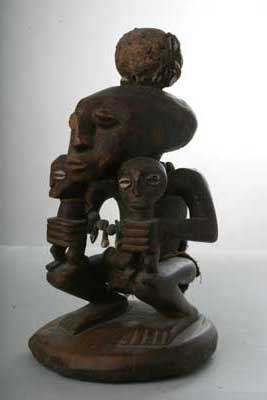 Lega, d`afrique : Rép.démoncratique du Congo., statuette Lega, masque ancien africain Lega, art du Rép.démoncratique du Congo. - Art Africain, collection privées Belgique. Statue africaine de la tribu des Lega, provenant du Rép.démoncratique du Congo., 11/164.Statue fétiche représentant un ancêtre accroupi en tenant deux enfants debout sur ses genoux.Sur sa tête allongée
se trouve une boule qui était richement entourée de cauries.Les yeux des enfants sont fait avec des  cauries.La statue porte des très vieilles perles locales et des dents.Bois,cauries,perles locales,dents, tissu en fibres d