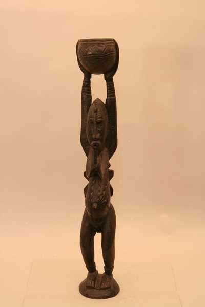 Dogon.(statue), d`afrique : Mali., statuette Dogon.(statue), masque ancien africain Dogon.(statue), art du Mali. - Art Africain, collection privées Belgique. Statue africaine de la tribu des Dogon.(statue), provenant du Mali., 1105/4196.Statue dogon H.52,50cm.x9cm. Représentant une femme avec des gros seins,ou hermaphrodite ayant une bouche ronde avancée avec une barbe, ou labret. Elle est debout,tenant un récipiant au-dessus de la tête.;Les scarifications sur le visage,sur les gros seins et le ventre sont faites avec des dessins géométriques, comme les statues appelées Dyonyeni, associées à la société méridionale Dio ou à la société Kwore.bois à épaise patine noire 1ère moitié du 20eme sc.(Nafaya). art,culture,masque,statue,statuette,pot,ivoire,exposition,expo,masque original,masques,statues,statuettes,pots,expositions,expo,masques originaux,collectionneur d`art,art africain,culture africaine,masque africain,statue africaine,statuette africaine,pot africain,ivoire africain,exposition africain,expo africain,masque origina africainl,masques africains,statues africaines,statuettes africaines,pots africains,expositions africaines,expo africaines,masques originaux  africains,collectionneur d`art africain